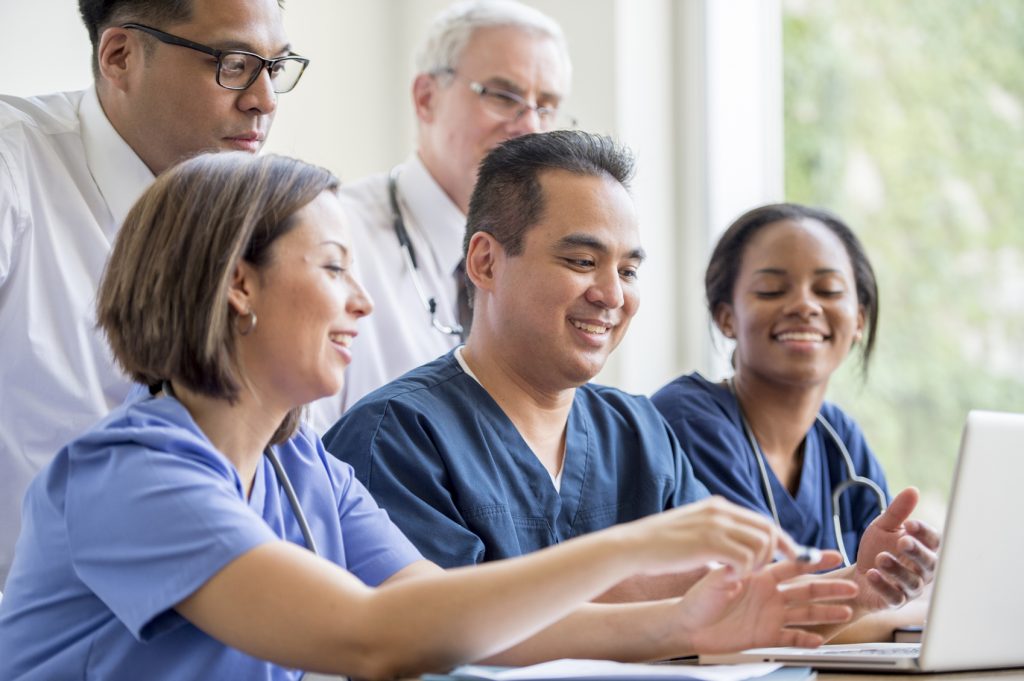 A multi-ethnic group of hospital staff researching a new procedure.